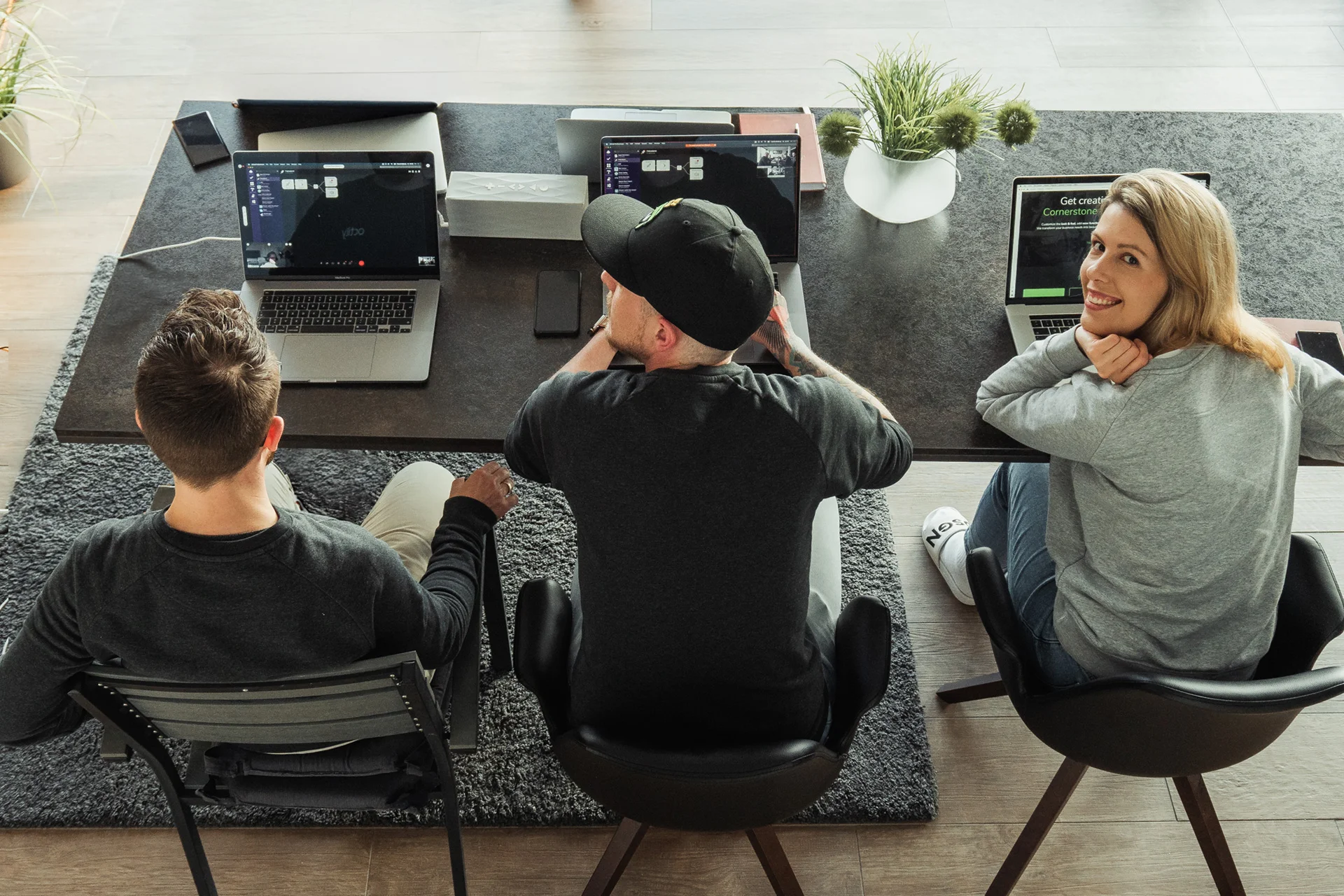 Team collaborating around laptops in a modern workspace